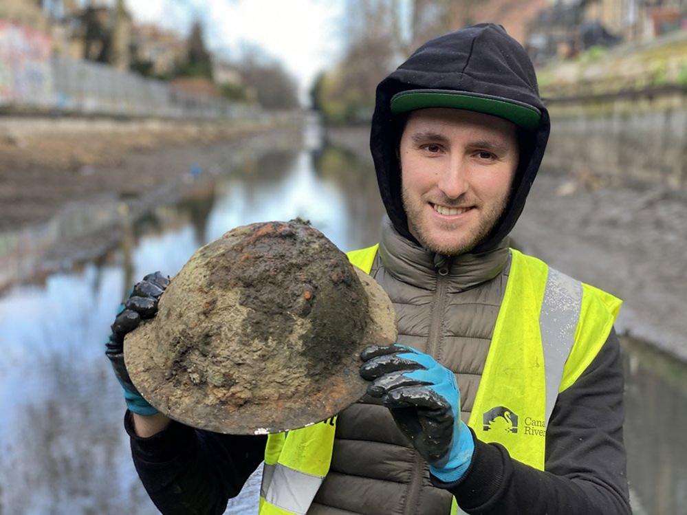 Mike Walker holding a helmet from World War Two