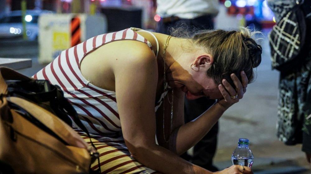 An Israeli woman holds her head in her hands in Tel Aviv