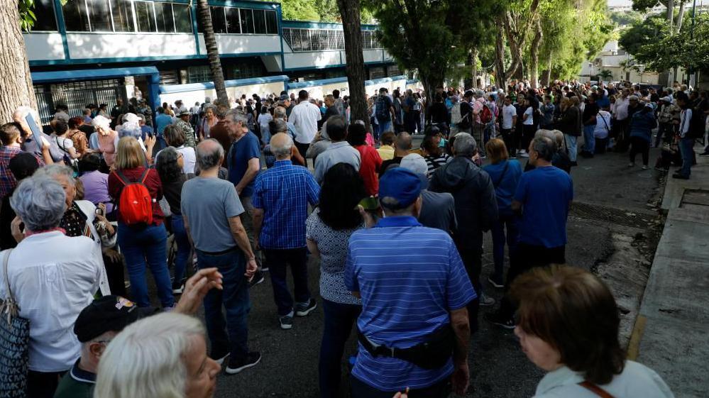 People queue to cast their vote at a polling station during the presidential election, in Caracas, Venezuela, July 28, 2024. 