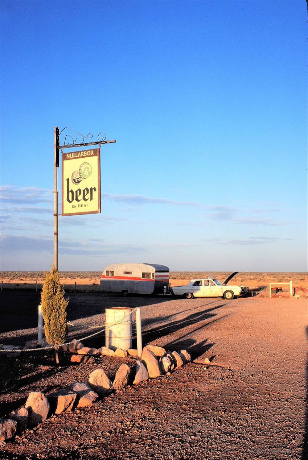 A sign for beer beside a road