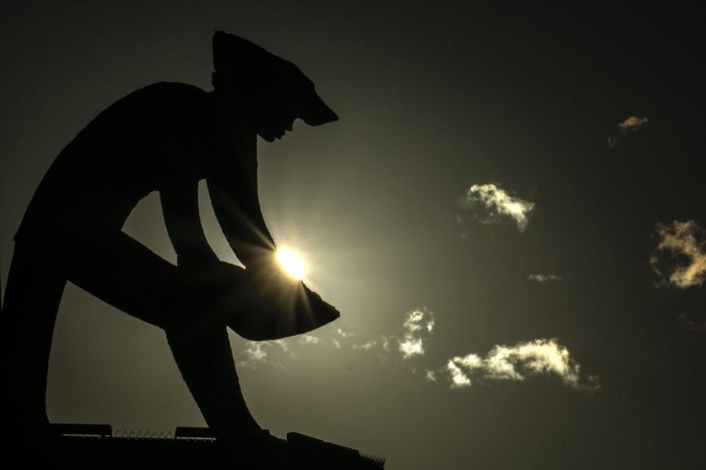 The silhouette of a miner is seen against the sun