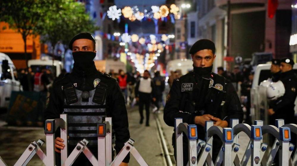 Police officers block the street after an explosion in Istanbul, Turkey