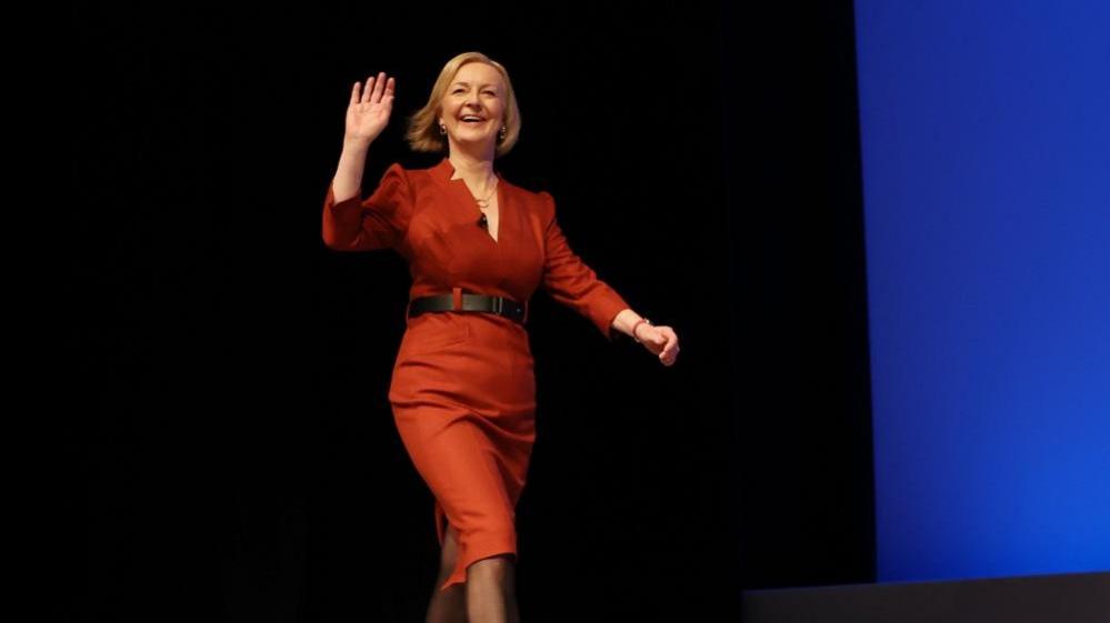 Liz Truss walks on stage to deliver her speech at the Conservative Party conference