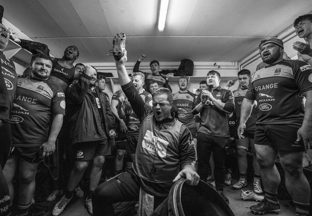 players in a rugby changing room, celebrating