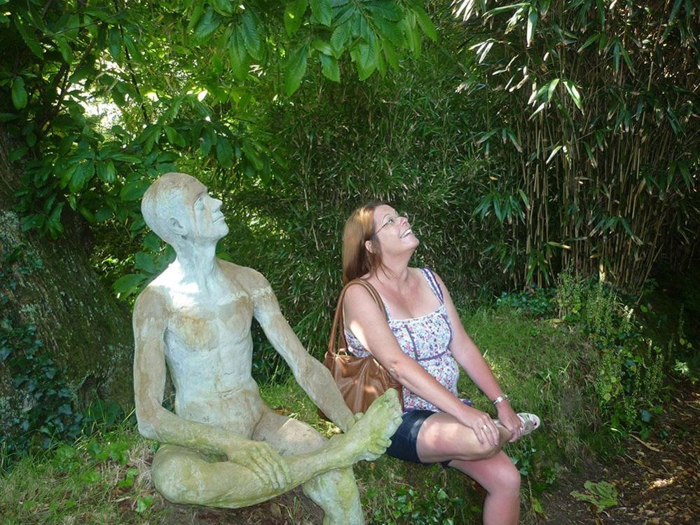 Woman sitting with a sculpture of a figure