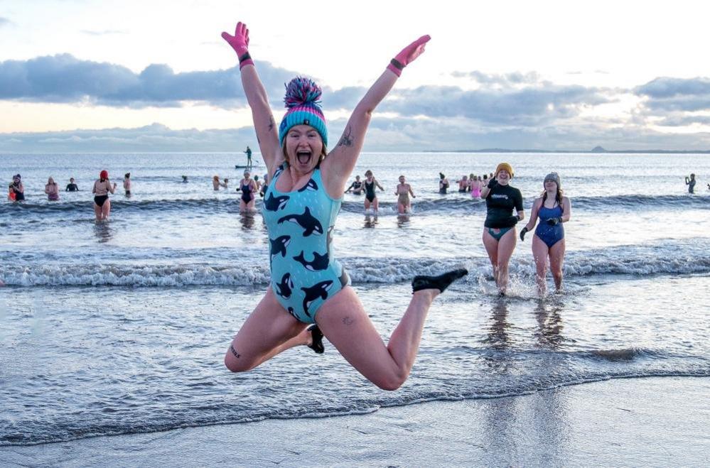 A swimmer jumps in front of the sea