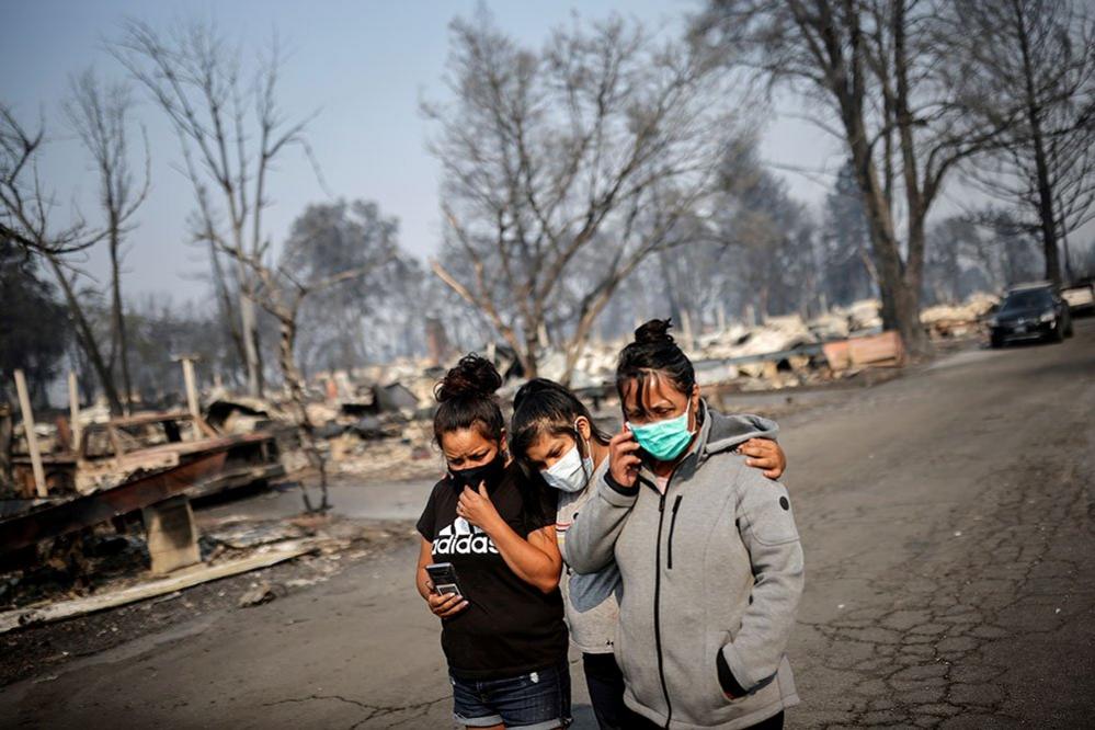 Sandra, Daniela, and Ester Reyes react while visiting their destroyed trailer home after the wildfires destroyed a neighbourhood in Bear Creek, Phoenix, Oregon