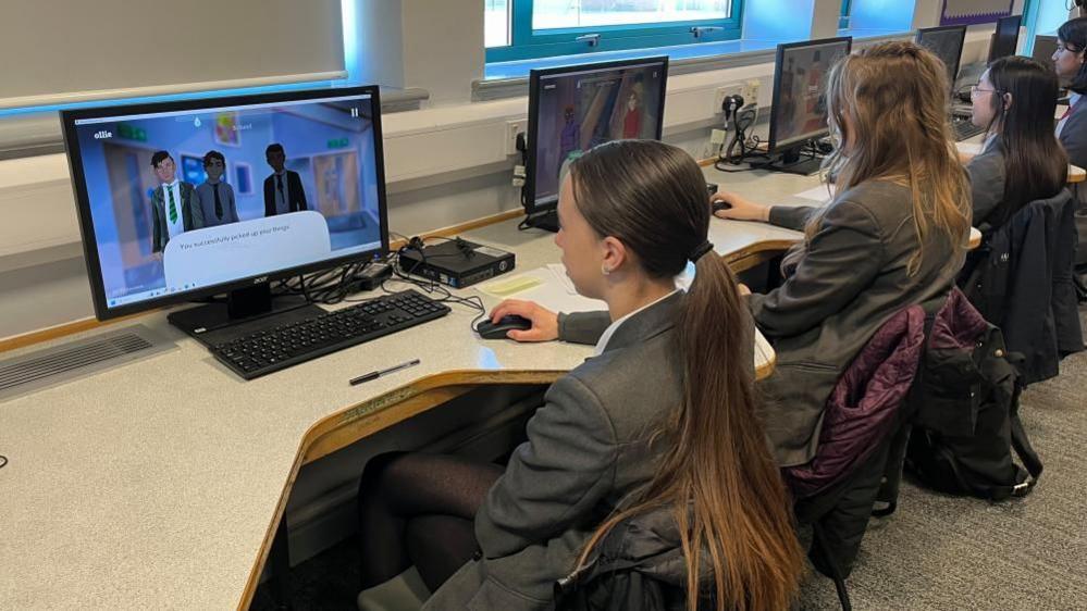 Pupils in uniform operating computers