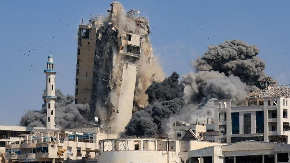 A tower in Gaza City collapses after it was hit by an Israeli missile 
