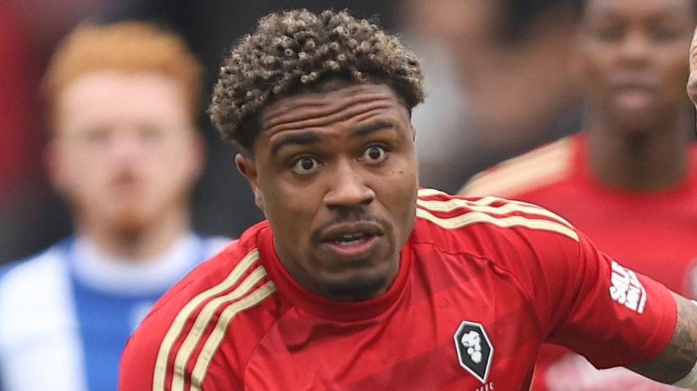Ossama Ashley, wearing Salford's red home shirt, pictured during a game against Oldham in 2025
