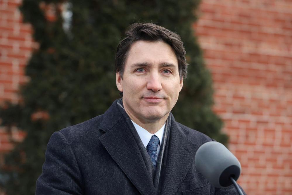 Canadian Prime Minister Justin Trudeau seen stood behind an outdoor podium while announcing his resignation