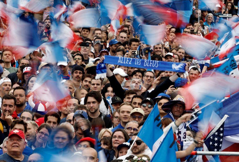 Spectators in red, white and blue wave flags