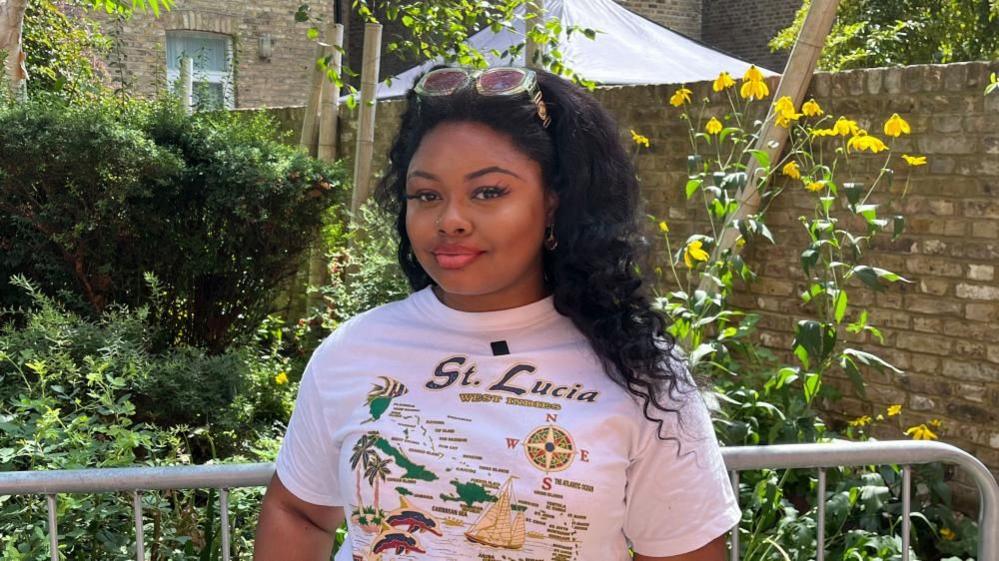 DJ Jada Pink stands in a garden in west London wearing a St Lucia T-shirt during an interview about Notting Hill Carnival.