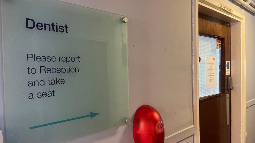 Sign pointing patients to the dental surgery and waiting area