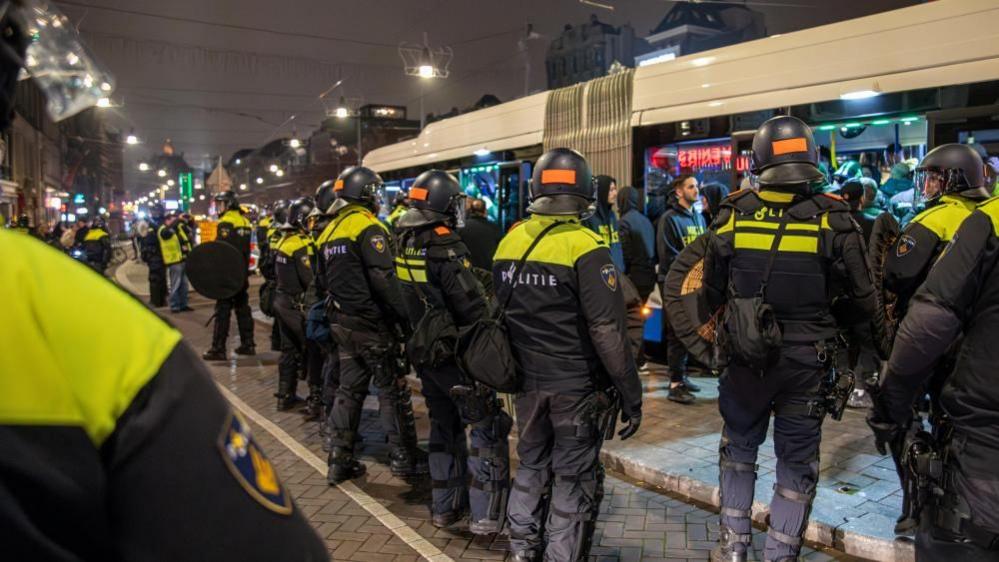 Dutch mobile police officers stand guard after several scuffles broke out in the city center following the UEFA Europa League match