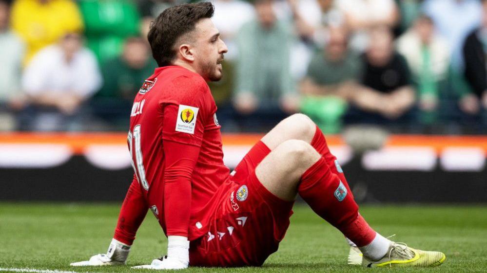 St Mirren goalkeeper Ryan Mullen sits injured on the Hampden turf