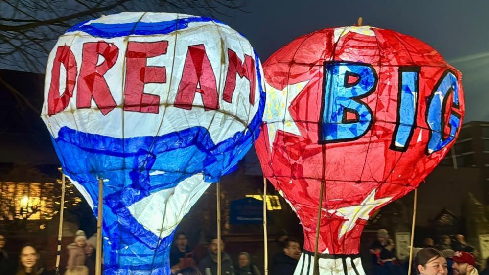 Two paper lanterns of hot air balloons, with the words "dream big" written on them