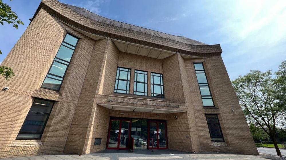 The main entrance to Cardiff Magistrates' Court, which has two floors and a paved area in front of the building 