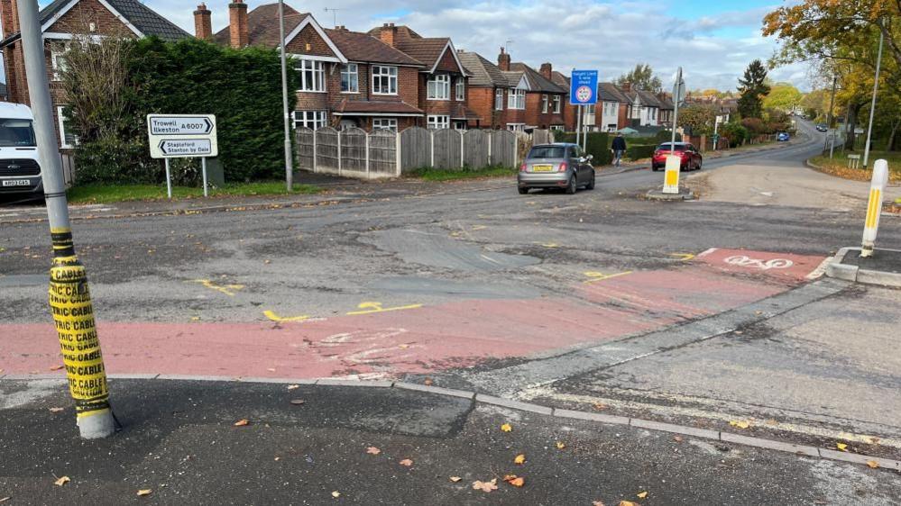 A view of the junction between Ilkeston Road and Pasture Road, with a dishevelled bike lane visible in the foreground.