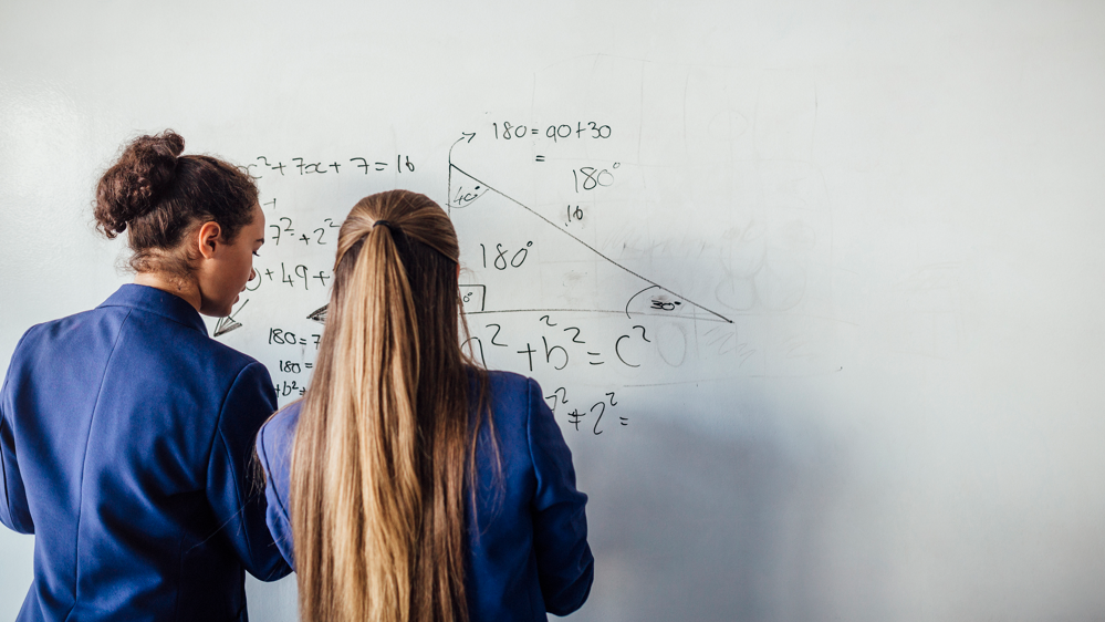 Students writing on whiteboard