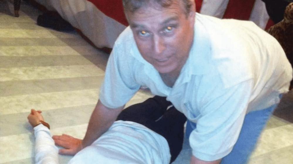 Andrew Mountbatten-Windsor kneeling on all fours over an unidentified female body lying on the ground.  