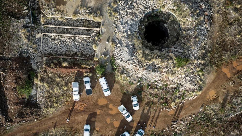 An aerial view of the mineshaft with some vehicles parked nearby