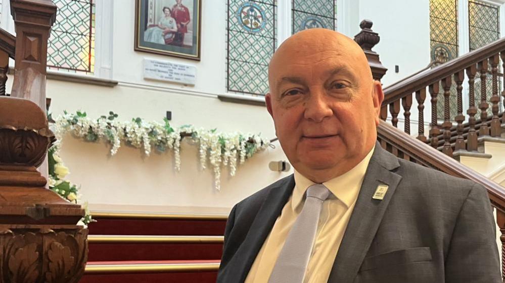 Councillor leader Carl Smith, stadning at the foot of the stairs at Great Yarmouth town hall