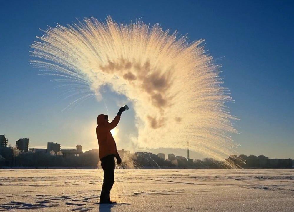 A man throwing a cup of hot water into the air