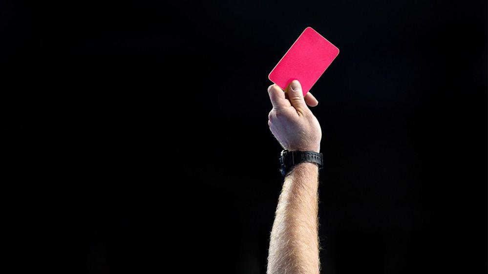 person holding up pink card