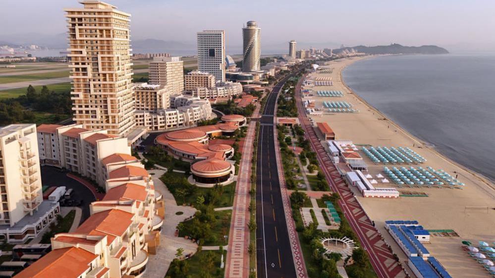 A Korean Central News Agency photo showing an aerial view of the Wonsan Kalma Coastal Tourist Zone, with dozens of buildings, an empty road and many beach umbrellas on the beachfront