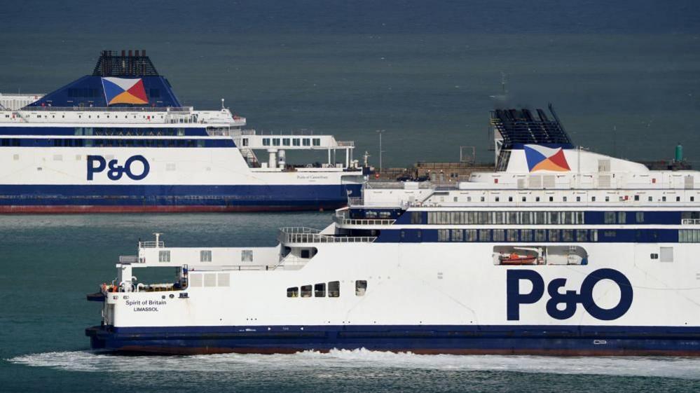 Two white ferries travel alongside each other on the ocean. They have 'P & O' written on their sides. 