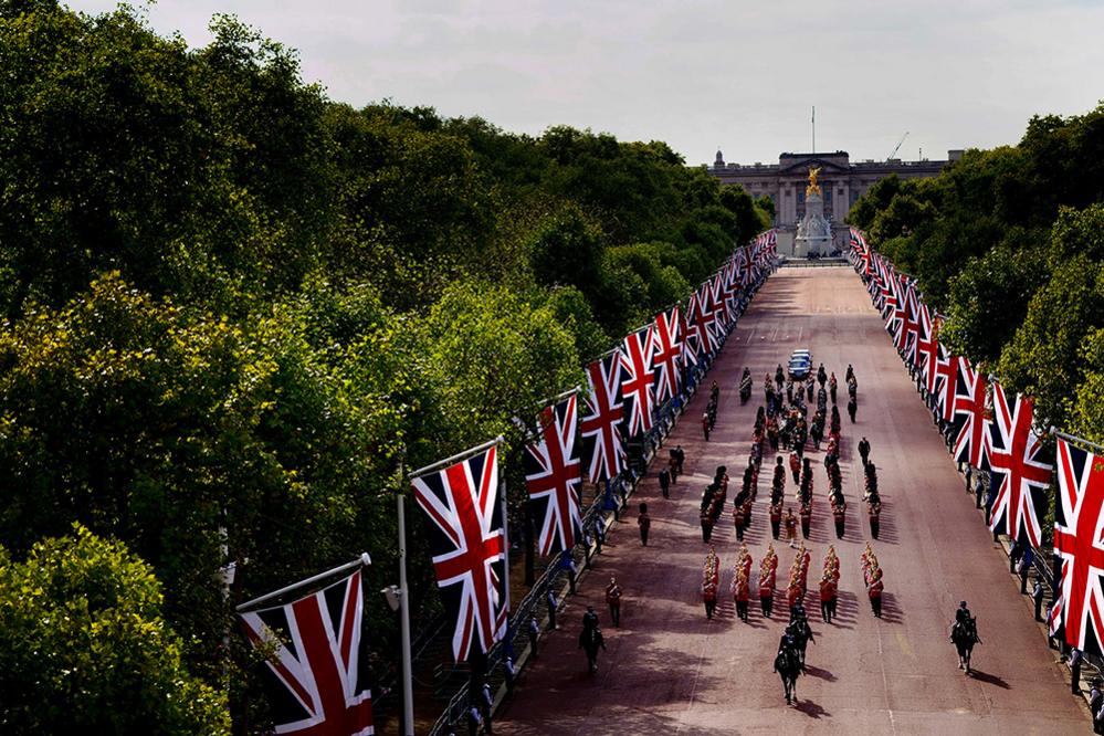 The coffin of Queen Elizabeth II, draped in the Royal Standard with the Imperial State Crown placed on top, is carried on a horse-drawn gun carriage of the King's Troop Royal Horse Artillery, during the ceremonial procession from Buckingham Palace to Westminster Hall