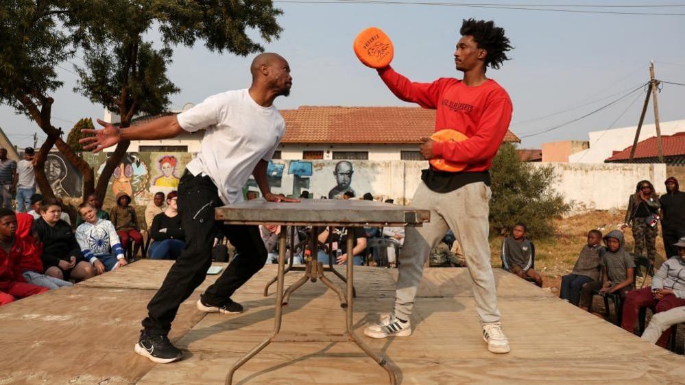 A contestant warms up on stage in preparation for a slap fighting match in Kagiso township, west of Johannesburg, South Africa - Sunday 4 August 2024.