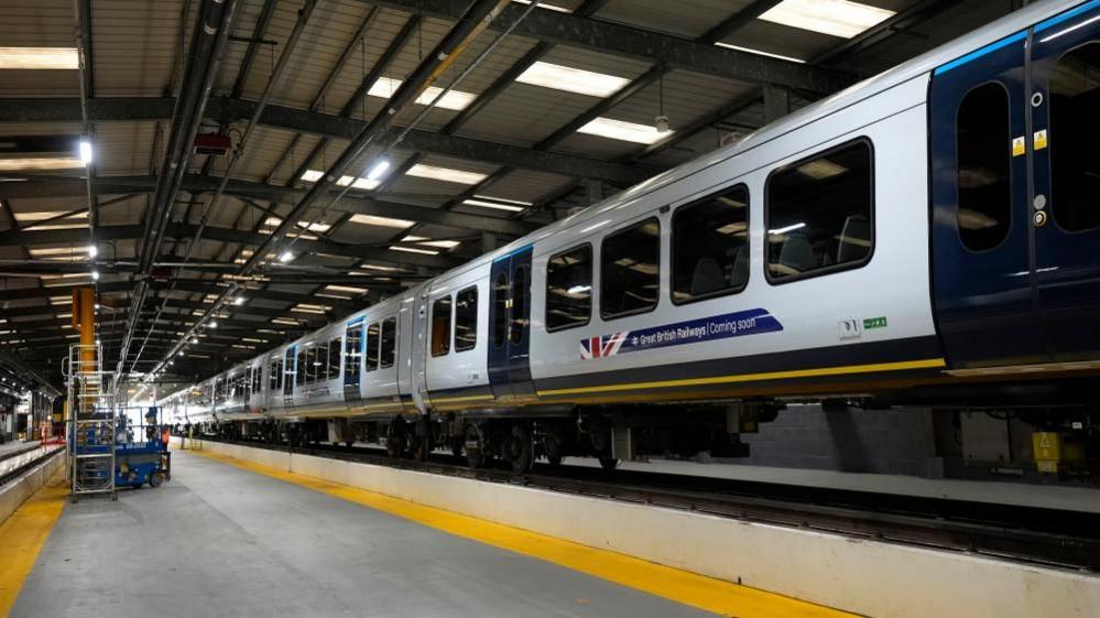 Train carriages painted with the new GBR livery and logo, they have been raised on a platform of some kind.