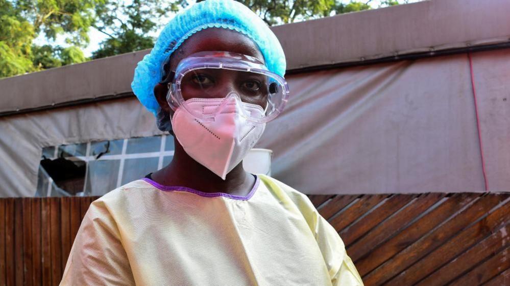 A health officer wearing protective clothing and mask.