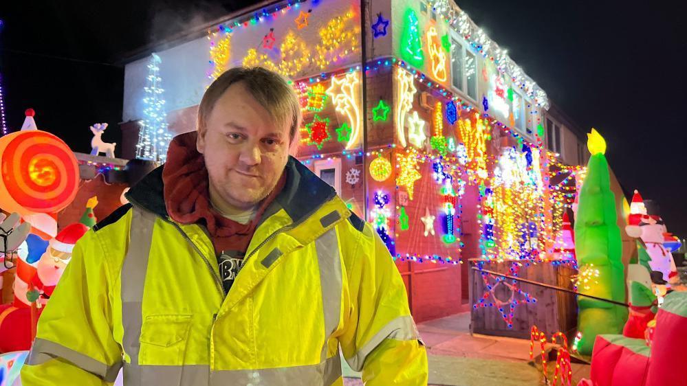 Scott Seare stood in front of his home, which has been thoroughly decorated in Christmas lights.