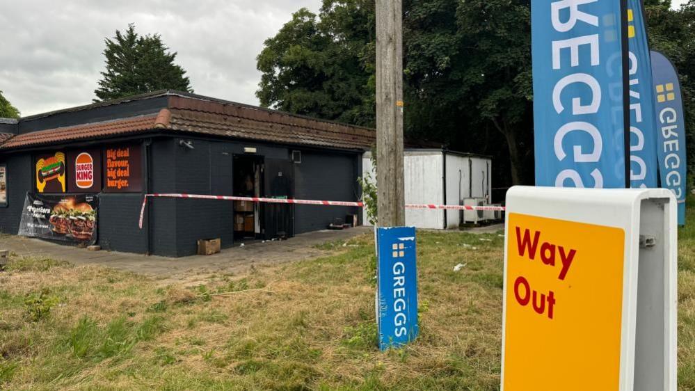 Signs for Greggs and Burger King at the scene of the fire