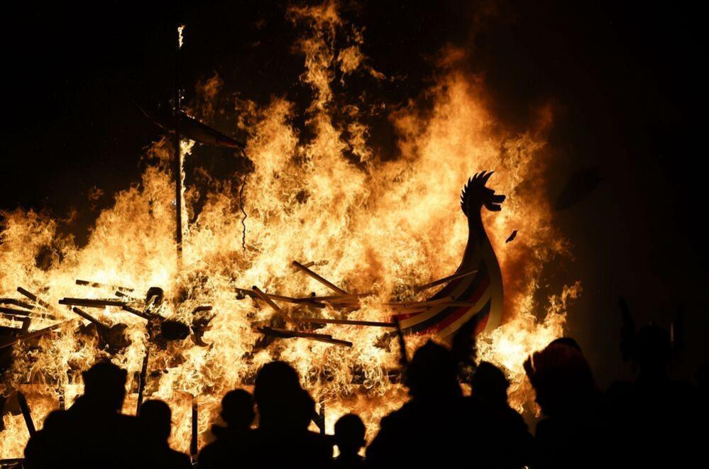 Spectators watch as a replica Viking ship is burned 