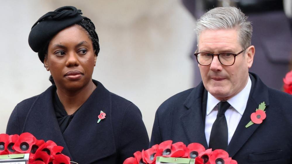 Kemi Badenoch and Sir Keir Starmer look solem as they stand holding poppy wreaths in November's remembrance event. 