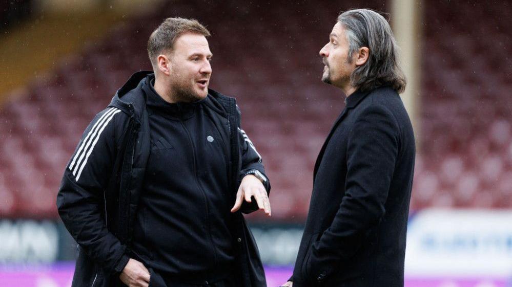 Peter Leven and Lutz Pfannenstiel of Aberdeen chat on the pitch at Fir Park, Motherwell
