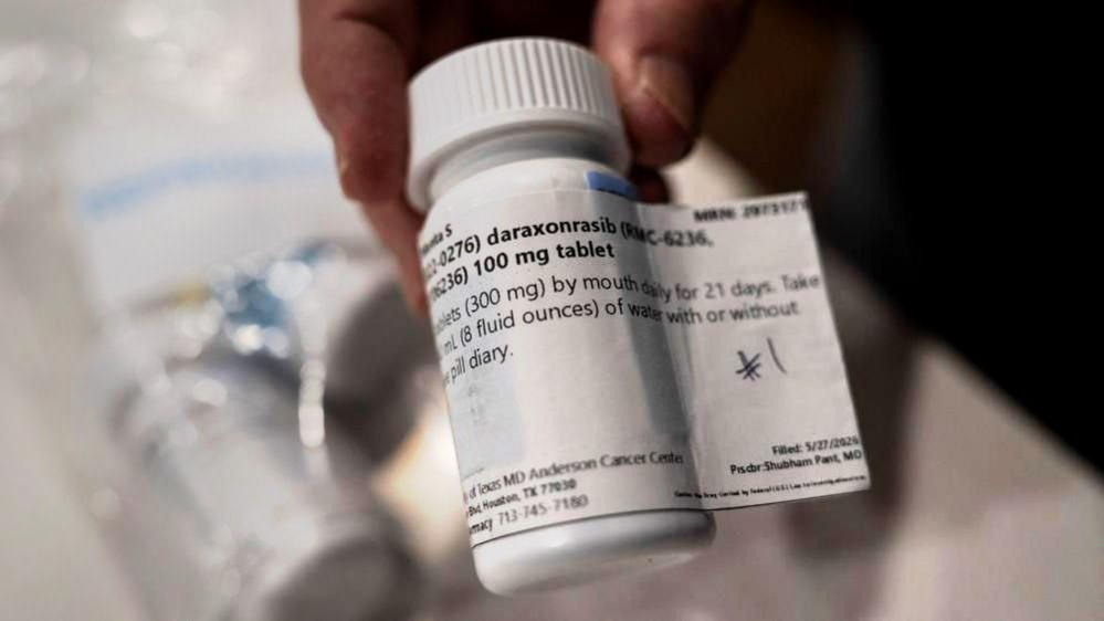 Close up image shows a pill bottle labelled daraxonrasib, in view are some of the label contents such as '300 mg' and 'by mouth daily for 21 days'.