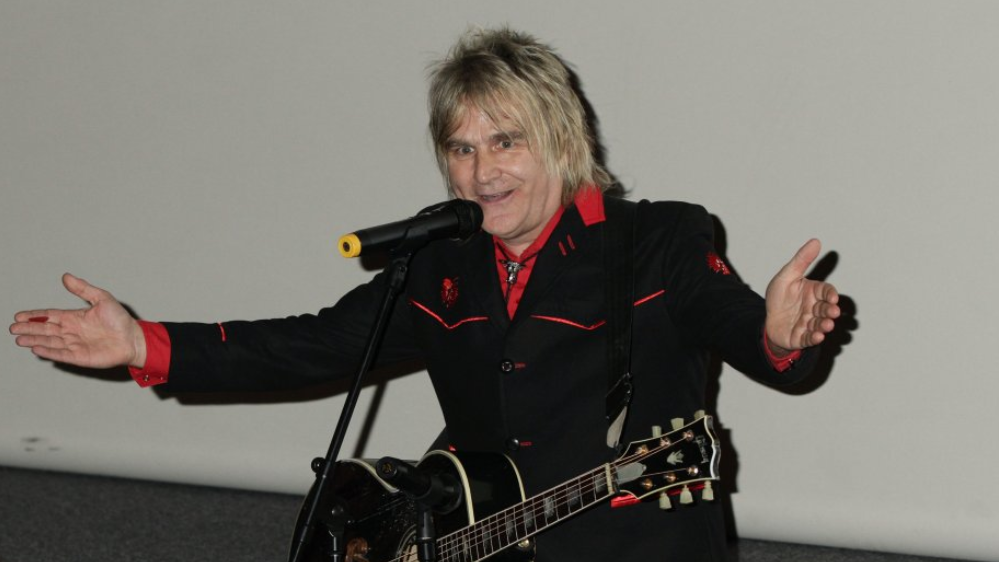 The Alarm frontman Mike Peters on stage with a guitar around his neck