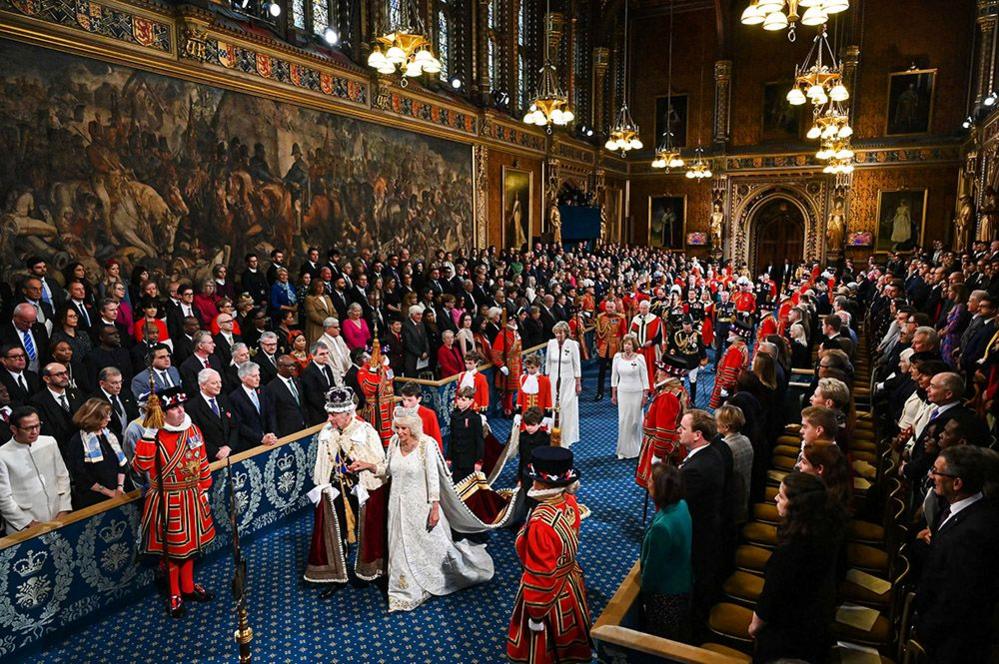 Britain's King Charles III, wearing the Imperial State Crown and the Robe of State, and Britain's Queen Camilla