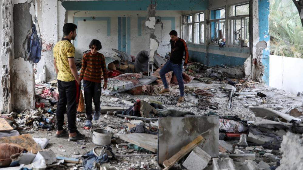 Palestinians at site of air strike on Nuseirat refugee camp