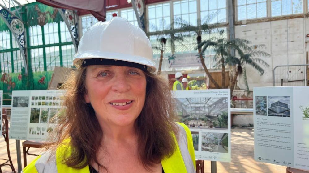 Landscape gardener Jennifer Coe standing near artists impressions inside the Winter Gardens