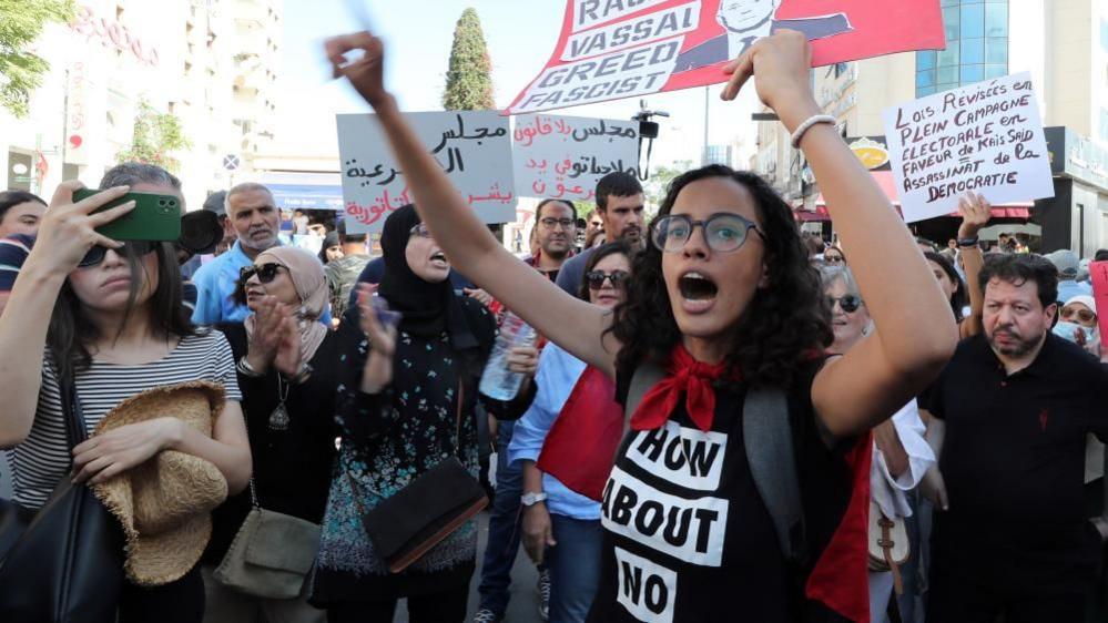 An image of protestors carrying banners and flags demanding that elections be free and fair - 27 September 2024