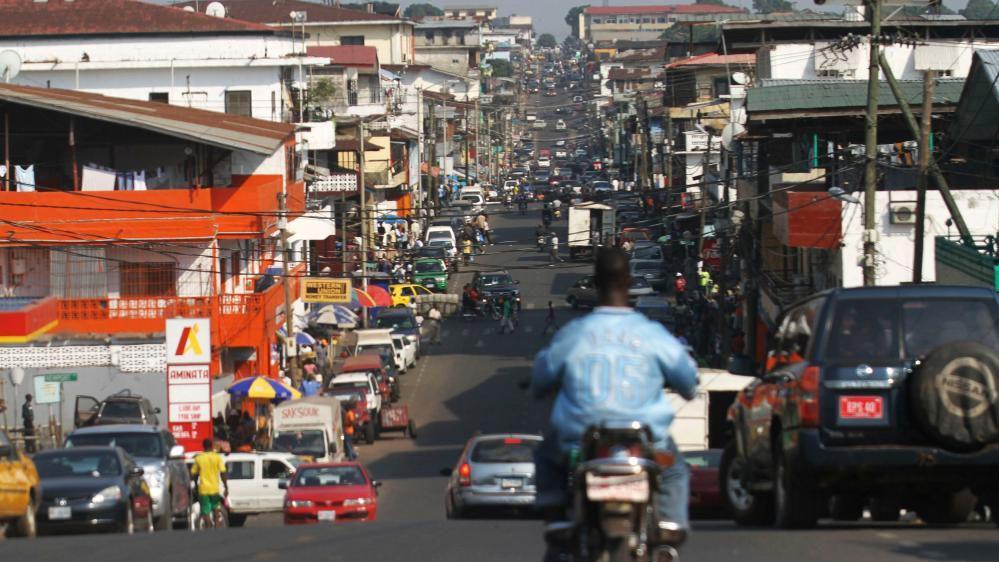 A view of a busy street in Monrovia - with many cars and shops
