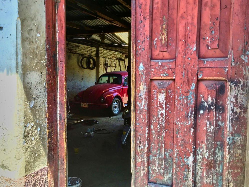 Volkswagen Beetle seen through a door that's ajar