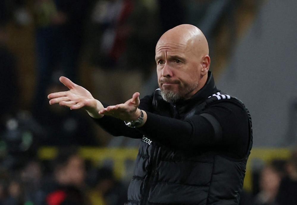 Former Manchester United manager Erik Ten Hag is seen gesturing from the sideline during a game. He is holding both hands outstretched and looking despondent. 