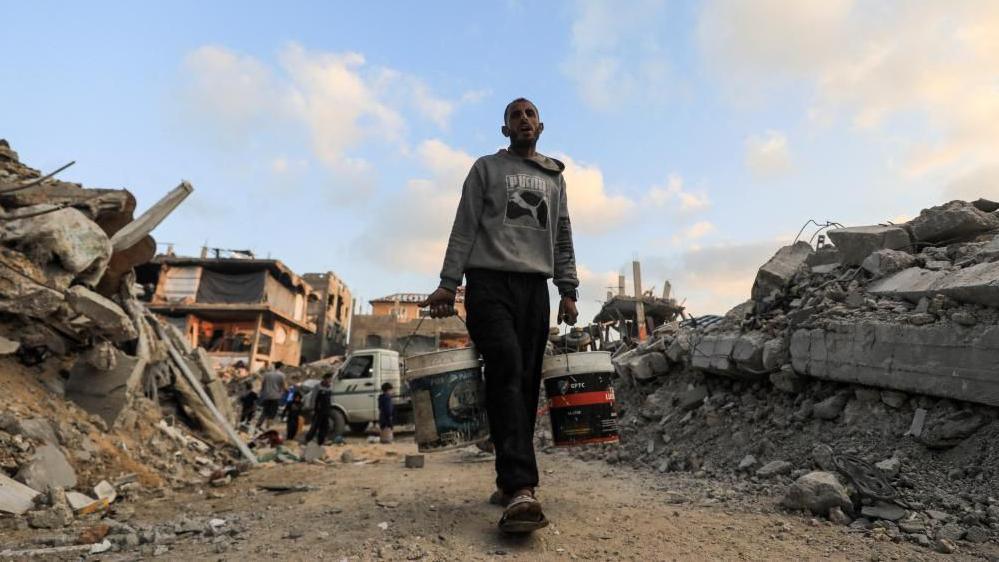 A Palestinian carries water in Jabalia refugee camp in Gaza